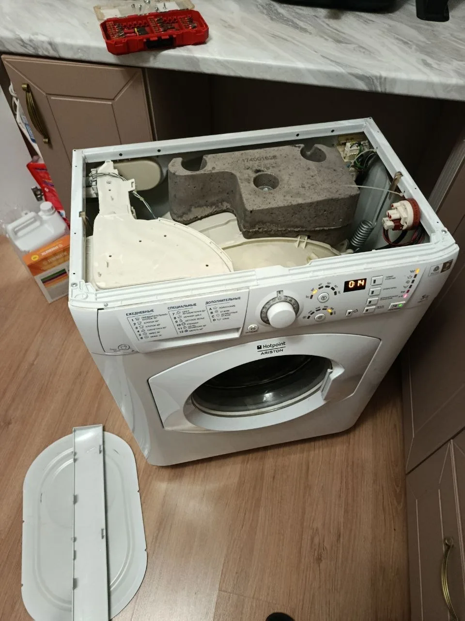 Стиральная машина Hotpoint Ariston во время диагностики со снятой верхней крышкой