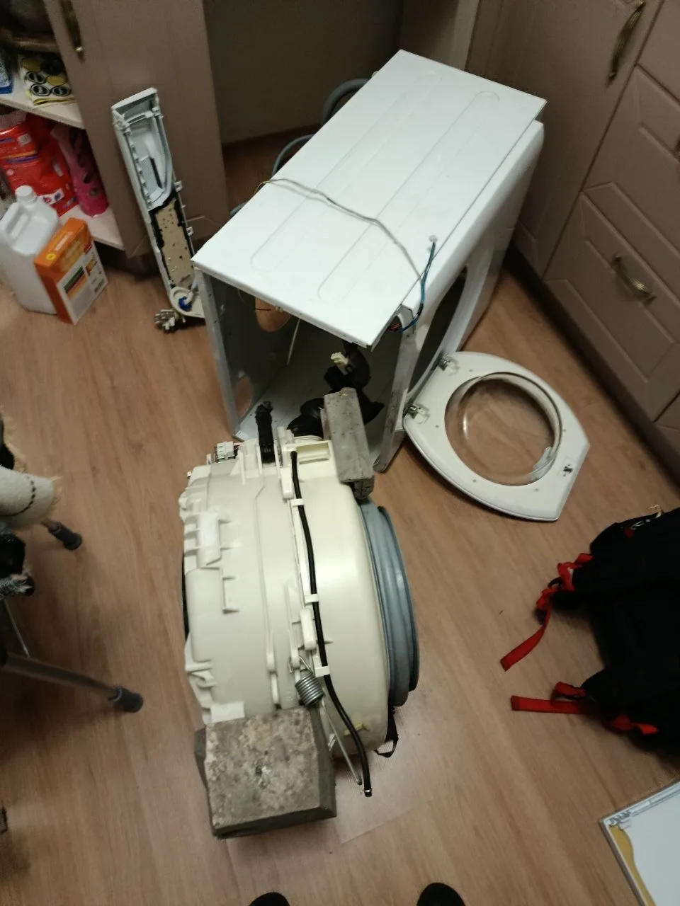 Стиральная машина Hotpoint Ariston в разобранном состоянии для доступа к амортизаторам